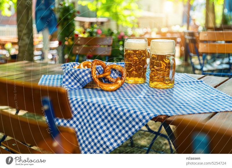 Bierkrüge mit frischen Brezeln oder Brezen auf dem Oktoberfest, München, Deutschland brezen bayerisch Stadtfest Bayern Wasserhahn Hintergrund Deutsche Flagge