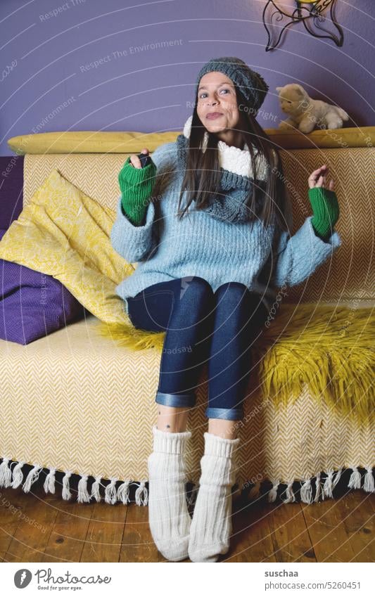 frau zu hause auf dem sofa Frau Zuhause Sofa warm angezogen kalt Winter Mütze Schal gemütlich Herbst gestrickt Wolle Pullover weich stricken Bekleidung bequem