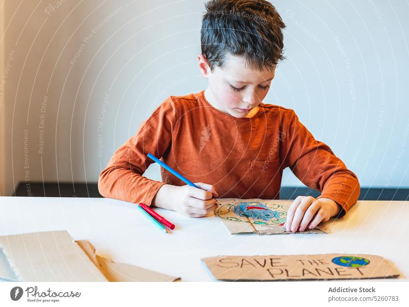 Junge Färbung Recycle Aufschrift Farbe wiederverwerten Umwelt Klassenraum plakatieren kreieren Kind Schachtel Tisch Schule Bildung Karton kreativ Aktivist