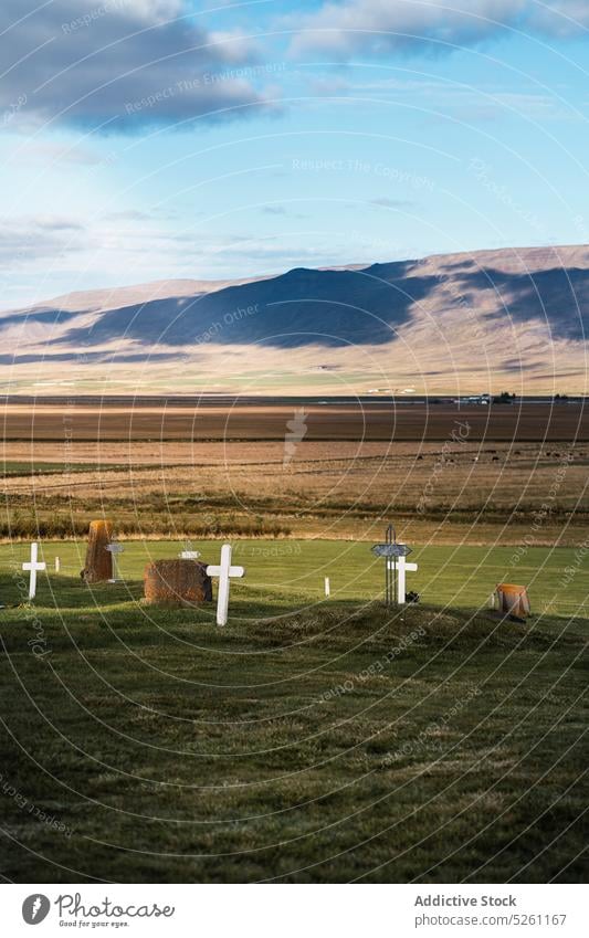 Katholischer Friedhof auf dem Lande Landschaft Grabstein grasbewachsen Tal Feld malerisch wolkig Gras Natur Island Blauer Himmel Sonnenlicht Gedenkstätte ruhig