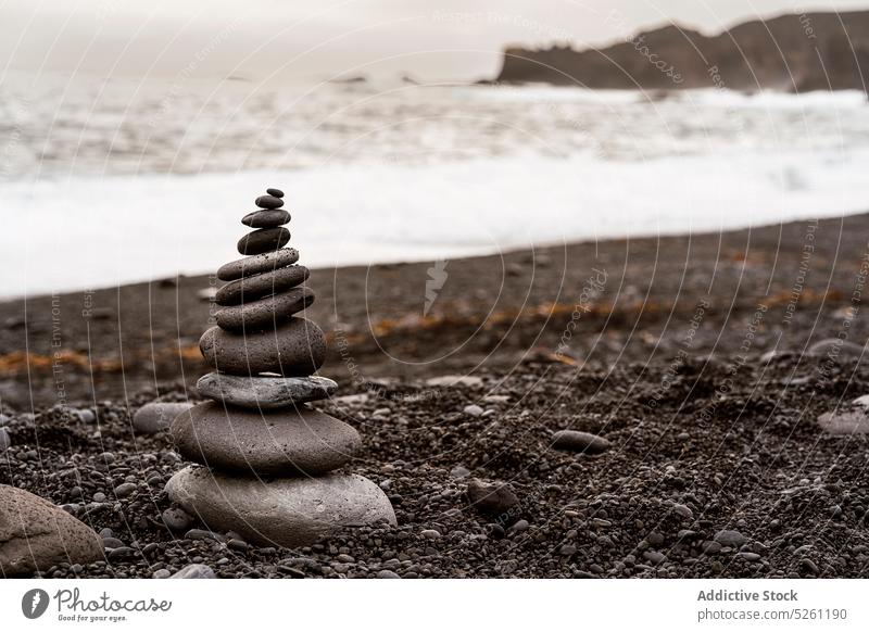Stapel balancierender Felsen am Meeresufer an einem bedeckten Tag Stein Strand vulkanisch Natur Landschaft Sand Gleichgewicht Zen Formation MEER malerisch