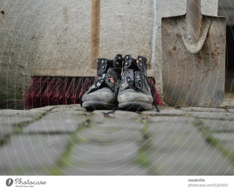 Spuren | verwischen,  Hausordnung machen ... Kehrwoche Bauarbeit arbeiten körperliche Arbeit Besen Spaten Schuhe Schmutz schmutzige Schuhe alt gebraucht