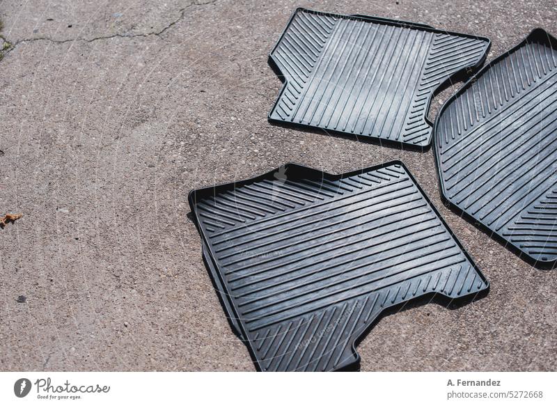 Drei Gummiboden-Autoteppiche liegen auf der Straße Boden. Auto Innenreinigung Konzept Autoinnenraum Matten Gummimatte Stock PKW Unterlage Innenbereich