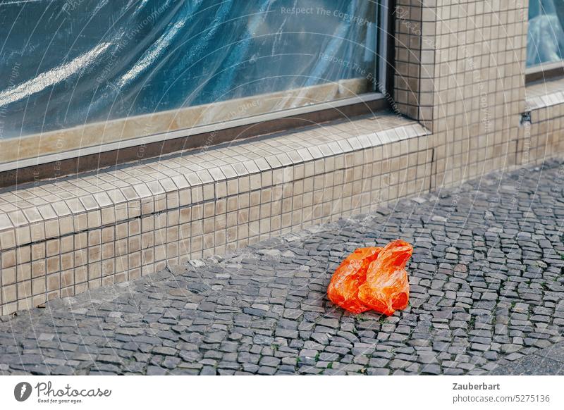 Rote Plastiktüte auf Gehweg vor großer Fensterscheibe, mit Plastikfolie verkleidet Tüte rot orange Müll Abfall Umwelt Umweltverschmutzung Stadt städtisch