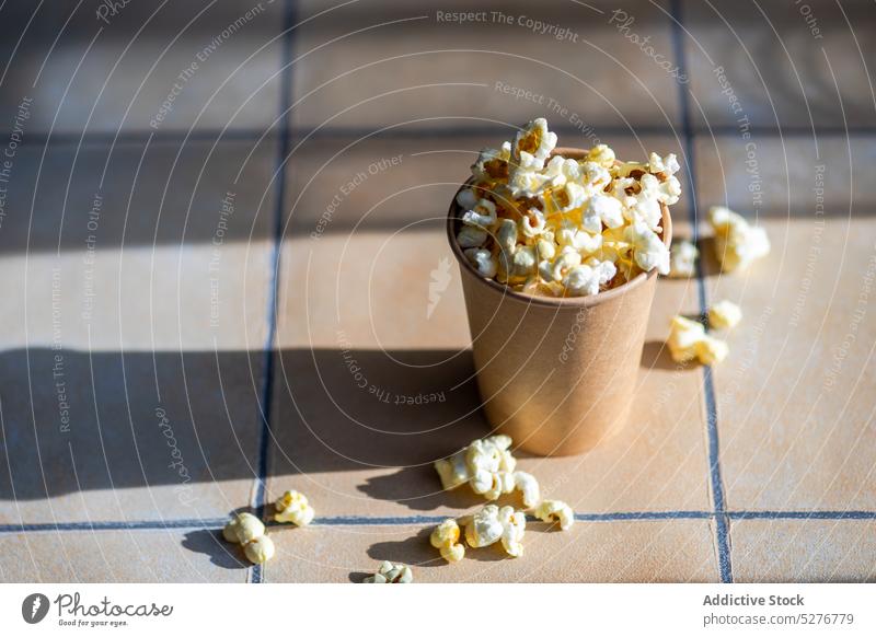 Pappbecher mit Popcorn-Snack Popkorn Hintergrund Keramik Kino abschließen Beton Container Mais knusprig Tasse essen Essen Fastfood fluffig Lebensmittel