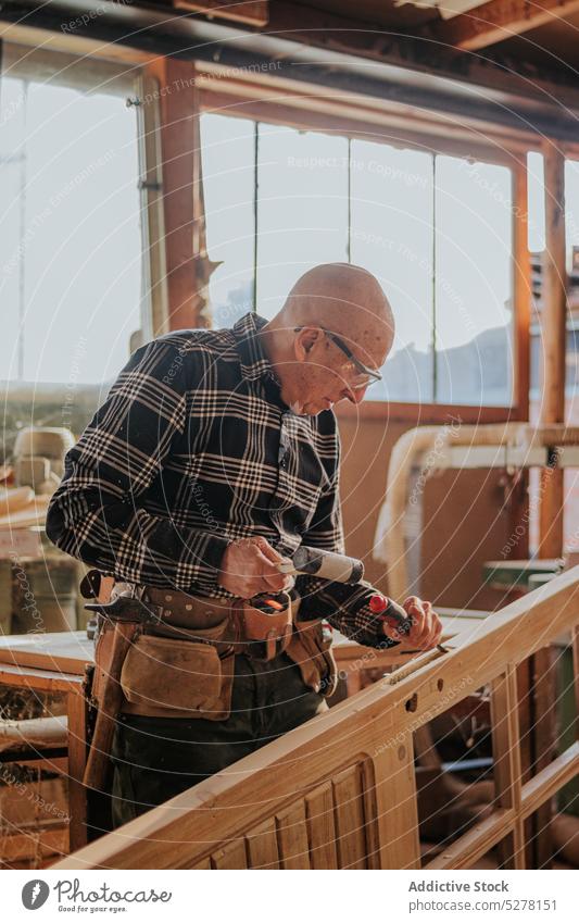 Senior Schreiner mit Meißel und Hammer in der Werkstatt Mann Beitel Tischlerin geschnitten Kunsthandwerker Schiffsplanken Holz Fähigkeit Kunstgewerbler