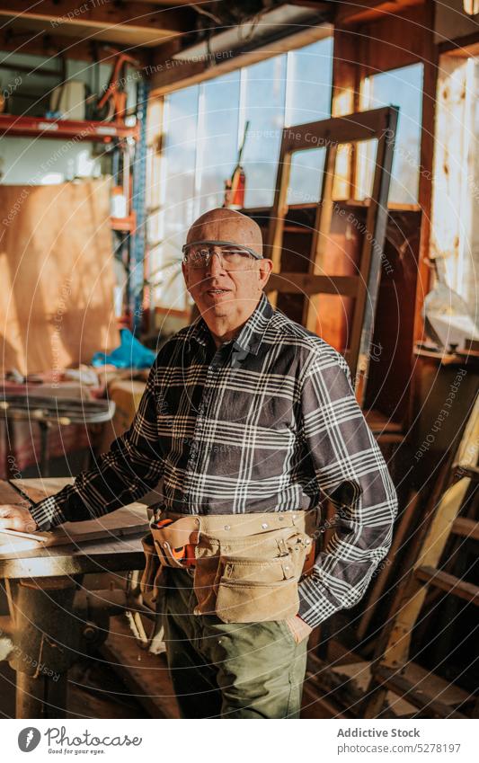 Älterer Handwerker schaut in der Werkstatt auf die Kamera Mann Zimmerer Tischlerarbeit professionell Arbeit Job Kunstgewerbler männlich Kunsthandwerker