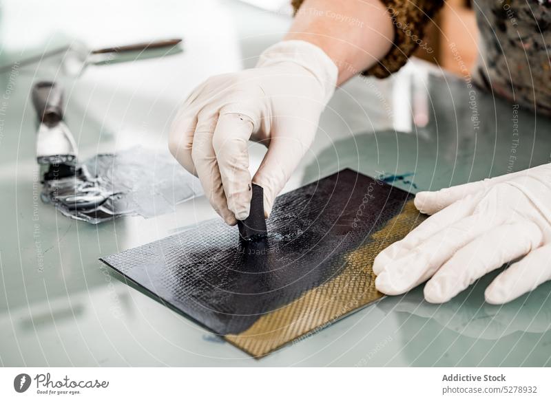 Kunsthandwerkerin beim Auftragen von Farbe auf einen Teller Handwerkerin Aufstrich Tusche Metall Schwamm professionell Werkstatt Fotogravur kreativ Frau