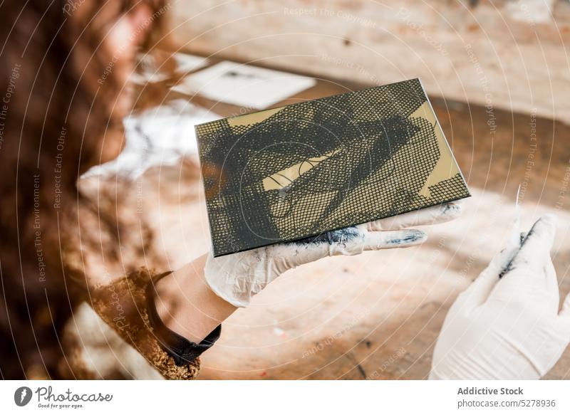 Kunsthandwerkerin mit Fotogravurplatte Handwerkerin Ornament Teller untersuchen Tisch Hobby abstrakt Werkstatt Frau Hobelbank Handschuh Tusche Beruf Gewebe