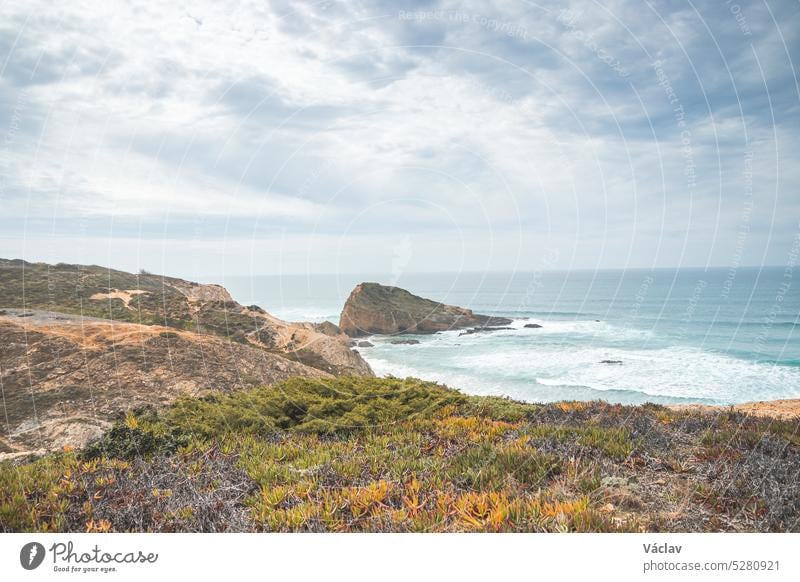 Blick auf den Strand Alteirinhos und die trockene Landschaft bei Zambujeira do Mar, Region Odemira, Westportugal. Wanderung entlang des Fischerpfads, Rota Vicentina