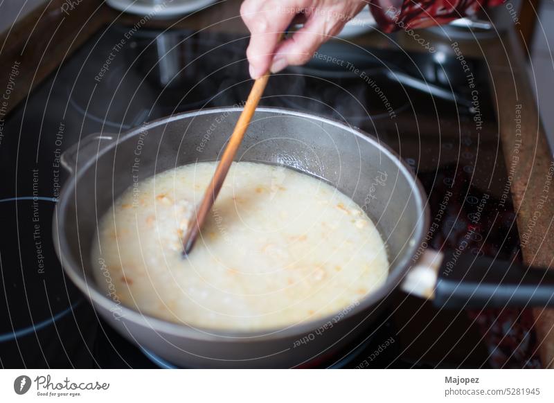 Ältere Frau rührt beim Kochen von Reis geschmackvoll selbstgemacht Hand traditionell Topf Vorbereitung Hintergrund heiß Küche alte Frau Kaukasier Hähnchen
