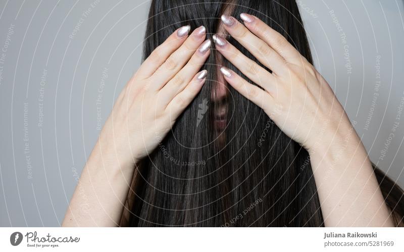 Frau hält sich die Haare vors Gesicht Model verstecken Strähnen lange Haare Dame Mensch Erwachsene Junge Frau Jugendliche weiblich Lifestyle Porträt Frisur