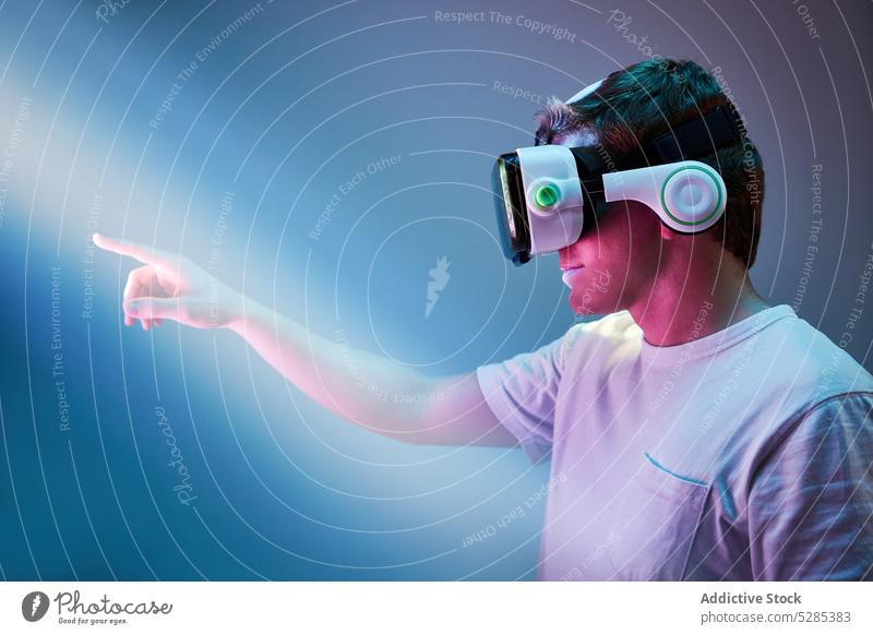 Anonymer Mann in VR-Headset erkunden Brille Cyberspace Schutzbrille neonfarbig Erfahrung Realität virtuell männlich Innovation Apparatur Virtuelle Realität