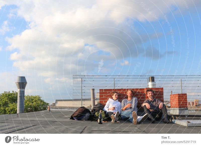 Drei Leute auf dem Dach beim Relaxen Prenzlauer Berg Wein Mann Frau Schornstein Stadt Berlin Außenaufnahme Stadtzentrum Hauptstadt Altstadt Tag Farbfoto Haus