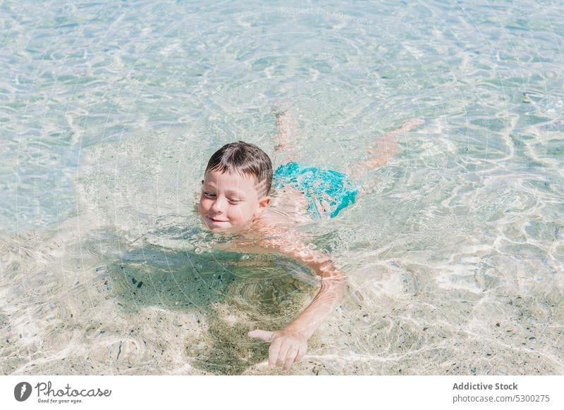 Glücklicher Junge schwimmt in sauberem Wasser Meeresufer schwimmen Resort nasses Haar MEER Kind Strand Pool Erholung Kindheit Aktivität aqua Feiertag Sauberkeit