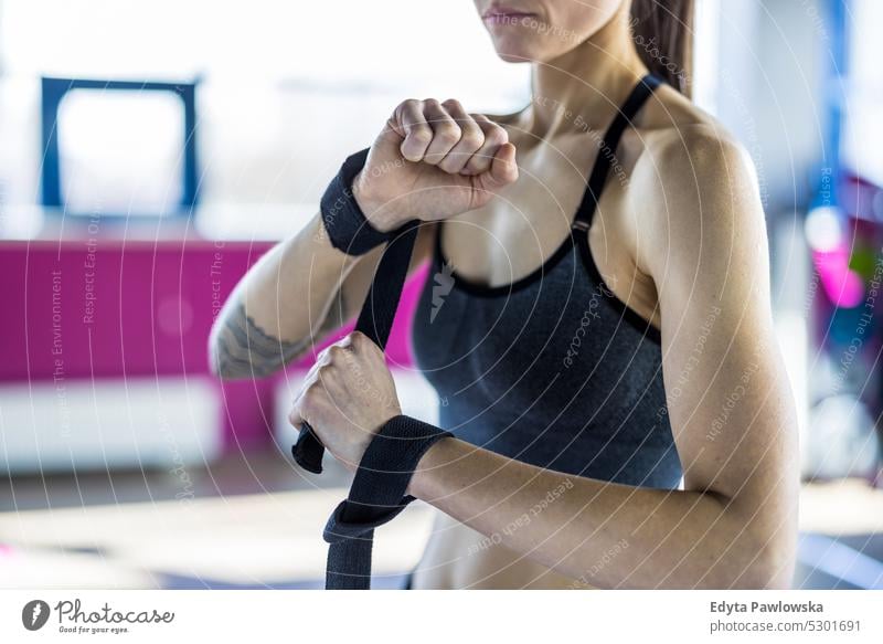 Mittelteil einer Frau, die mit einem Widerstandsband in einem Crossfit-Kurs im Fitnessstudio trainiert Wellness Wohlbefinden Bodybuilder sportlich Heben Bizeps