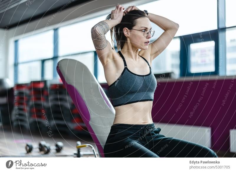 Porträt einer sportlichen jungen Frau beim Training in einem Fitnessstudio Wellness Wohlbefinden Bodybuilder Heben Bizeps Muskeln Curl-Hantel Bodybuilding