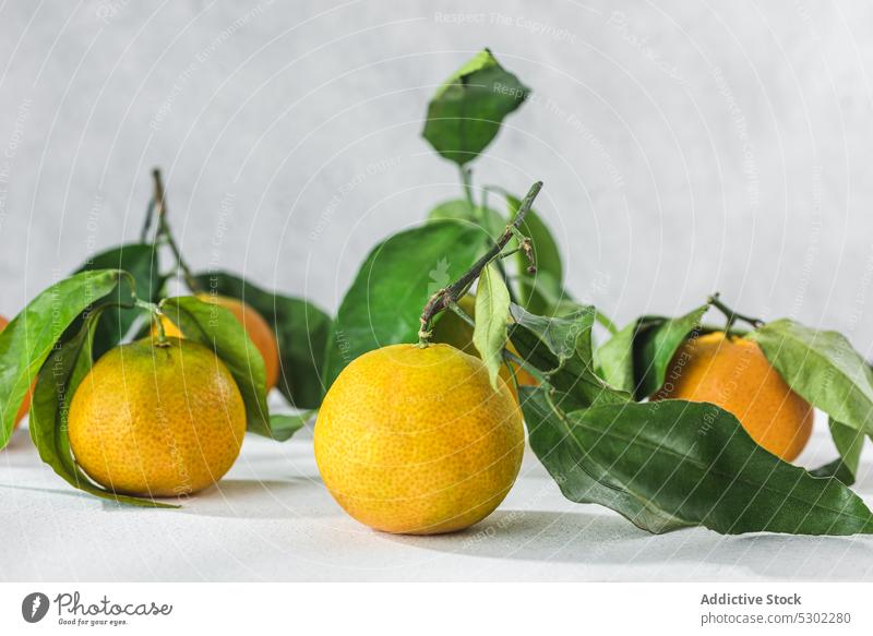 Orangefarbene Mandarine auf weißem Tisch orange Zitrusfrüchte pflanzlich Vorbau Blatt liegen gereinigt Blätter Frucht Mahlzeit Lebensmittel organisch Gesundheit