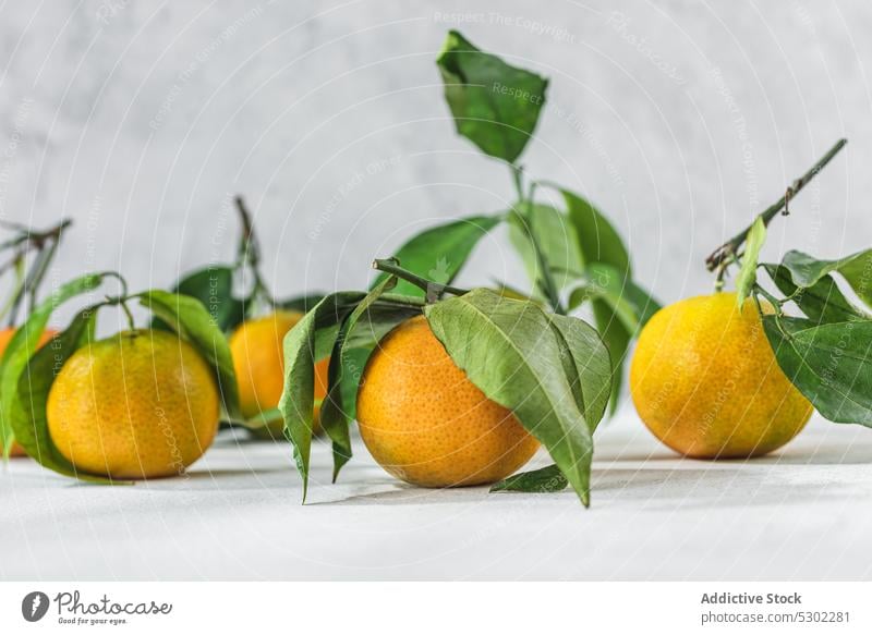 Orangefarbene Mandarine auf weißem Tisch orange Zitrusfrüchte pflanzlich Vorbau Blatt liegen gereinigt Blätter Frucht Mahlzeit Lebensmittel organisch Gesundheit