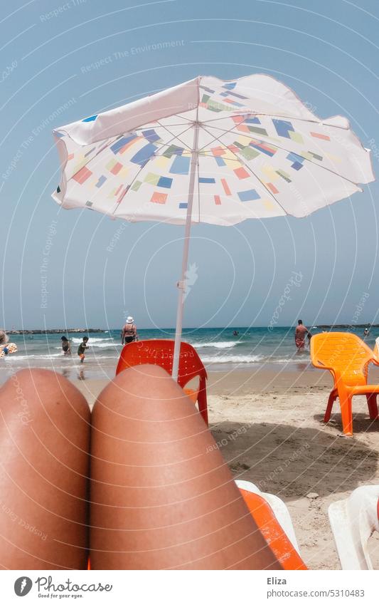 Oberschenkel am Strand mit Sonnenschirm im Badeurlaub - ein lizenzfreies Stock  Foto von Photocase