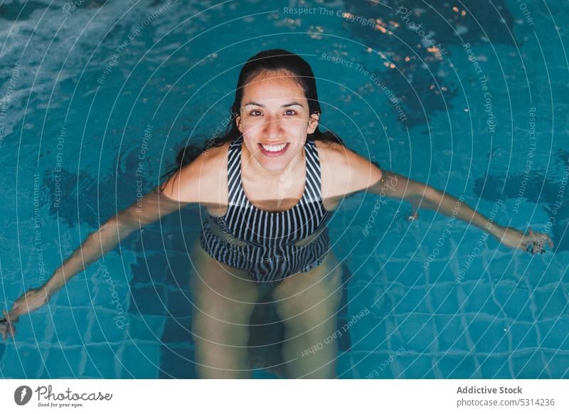 Glückliche Schwimmerin im Pool Frau heiter Lächeln Urlaub Resort Wasser sich[Akk] entspannen schwimmen Badeanzug Badebekleidung ruhen Streifen Feiertag Freude
