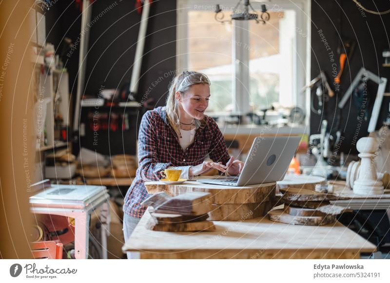 Schreinerin mit Laptop in einer Schreinerei echte Menschen Holzwerkstatt Zimmerer Unternehmer Kompetenz Werkstatt Handwerker Kreativität Herstellung Hobby
