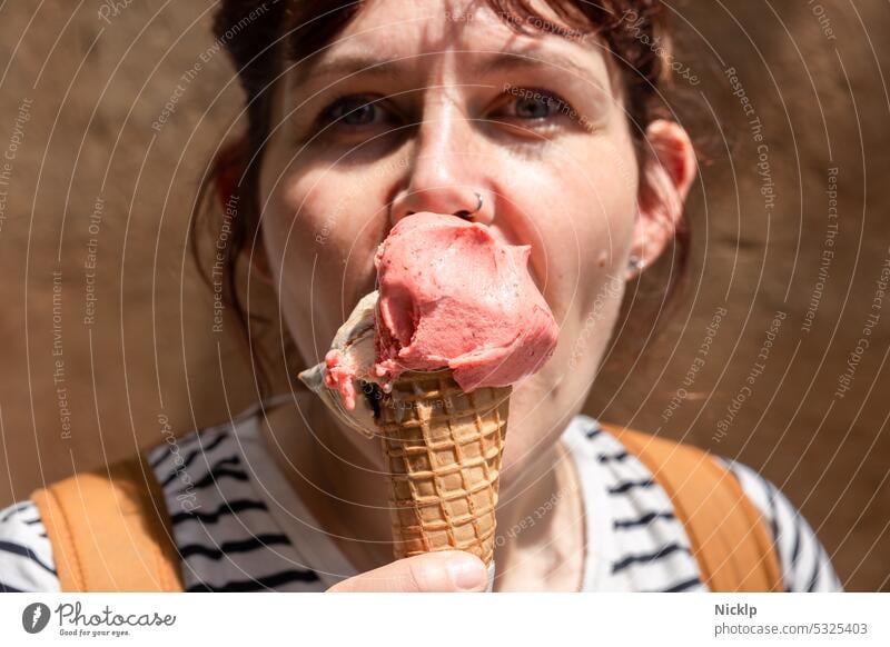 junge attraktive Frau leckt an einem Eis und schaut in die Kamera Junge Frau hübsch Eiscreme Sommer Italienisch Toskana Speiseeis Erdbeereis Waffel Eiswaffel