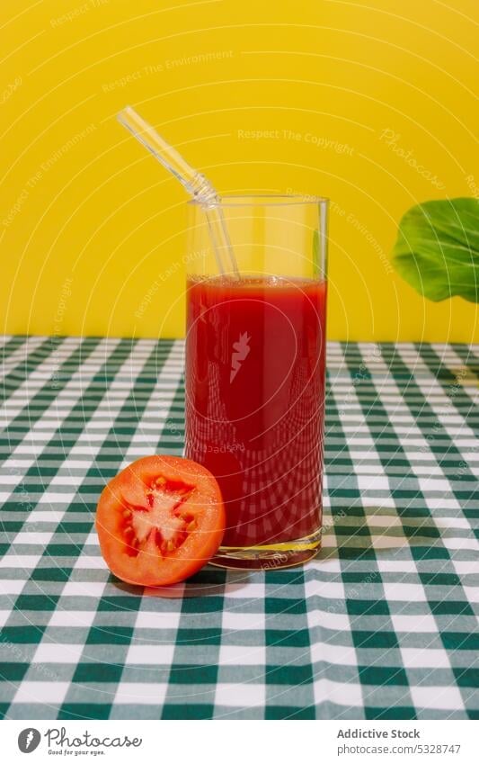 Glas erfrischender Tomatensaft mit Strohhalm Saft kariert umweltfreundlich keine Verschwendung Tischwäsche hell reif Hälfte Cocktail natürlich wiederverwenden