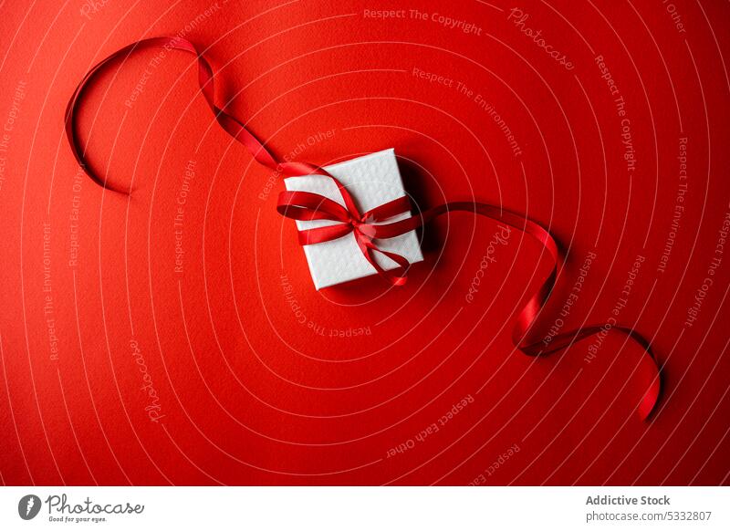 Weißer Geschenkkarton mit roter Schleife präsentieren Bändchen umhüllen Hintergrund Verpackung schön Kasten hell Postkarte Farbe farbenfroh Konzept festlich