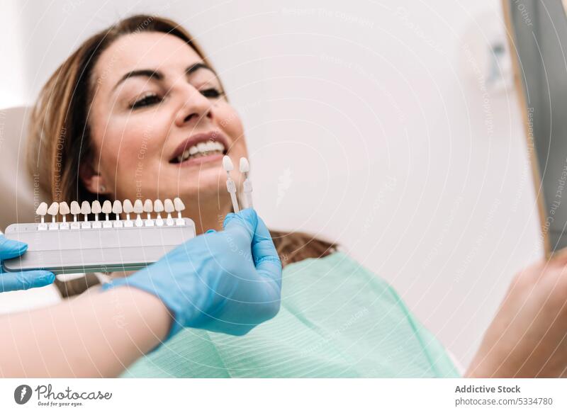 Zahnärztin zeigt dem Patienten Zahnverblendungen Zahnarzt zeigen geduldig Zähne Leckerbissen Arzt Stomatologie Arbeit Verfahren Frau Spezialist Furnier Latex