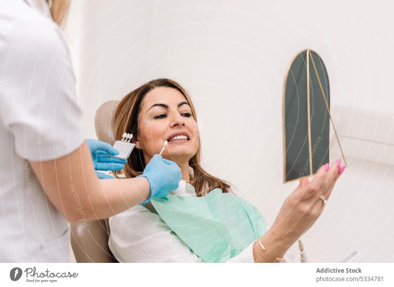 Zahnärztin zeigt dem Patienten Zahnverblendungen Zahnarzt zeigen geduldig Spiegel Zähne Leckerbissen Arzt Stomatologie Arbeit Verfahren Frau Spezialist Furnier