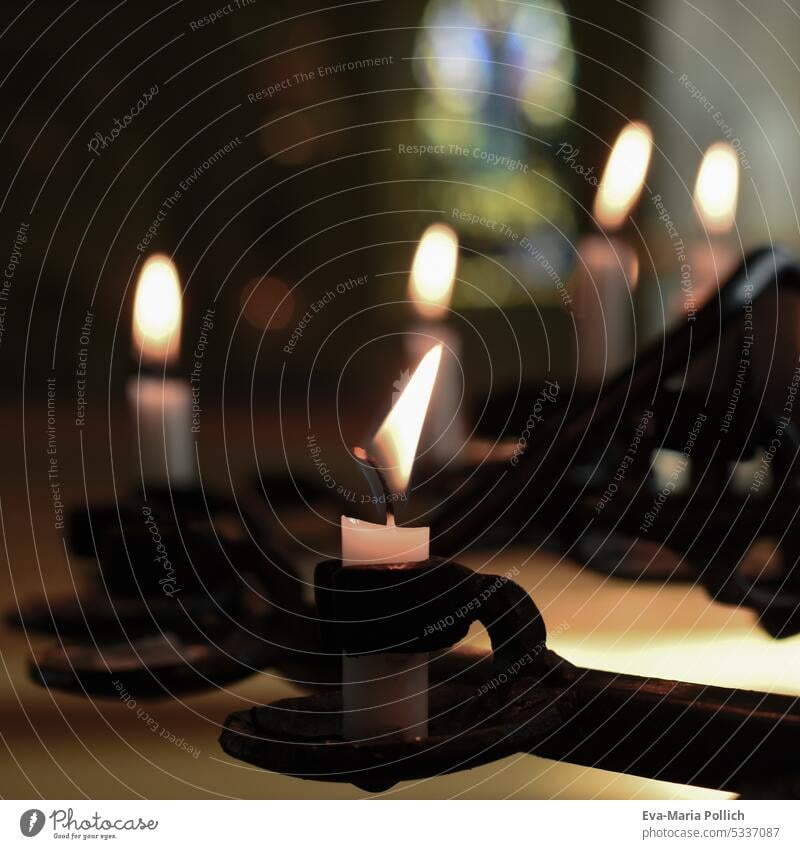 weisse brennende Kerzen in schwarzen Halterungen in einer Kirche Kerzenschein Religion & Glaube Gebet kerze trauer beten gott demut leben dunkelheit symbolbild