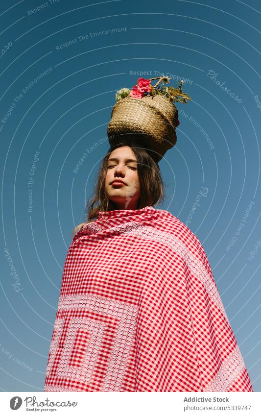 Ruhige Frau mit Weidenkorb auf dem Kopf verträumt Blume Korb Plaid Natur Augen geschlossen Landschaft sorgenfrei kariert Blauer Himmel jung Sommer wolkenlos