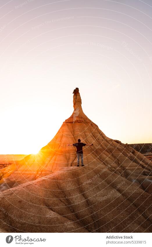Unbekannter Reisender vor einem Felsen in der Wüste bei Sonnenuntergang stehend Mann wüst Natur bewundern Tourist Berge u. Gebirge reisen felsig Fernweh