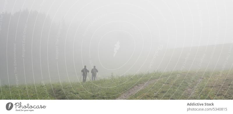 Anonyme Menschen auf einer nebligen Wiese Nebel nordische Wanderung Natur Feld Landschaft laufen dick Sport Gesundheit Wellness Wohlbefinden Wetter Gras