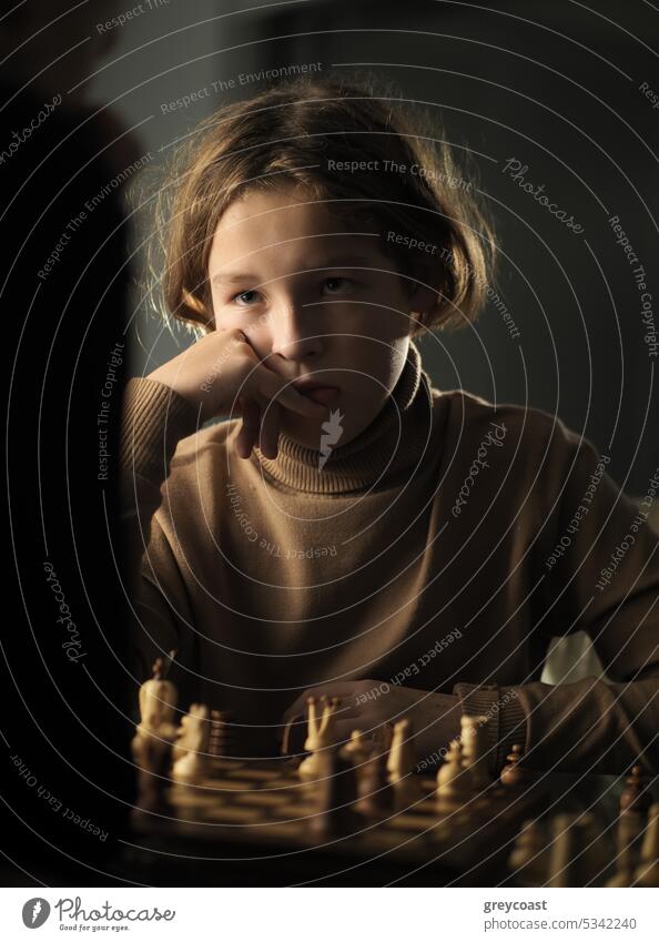 Der Teenager machte einen Zug beim Schachspielen Kind Schachbrett 12 Jahre alt Jugend Spiel Junge Spieler ernst Kaukasier jung Kindheit niedlich Hobby