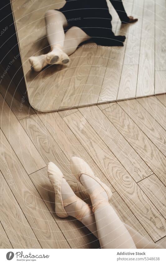 Anonyme Ballerina in Spitzenschuhen auf dem Boden Frau Atelier Balletttänzer spitze Tänzer Probe Choreographie Spiegel Stock Anmut klassisch sitzen üben ruhen