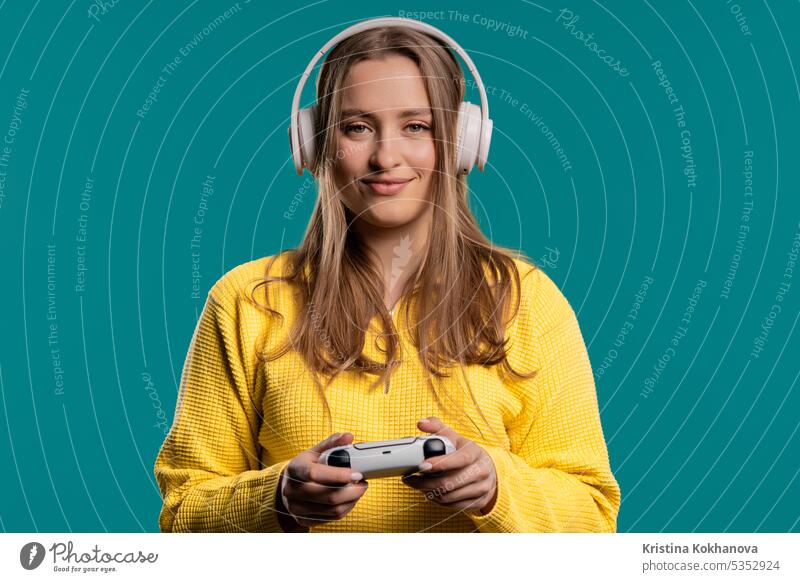 Junge Frau spielt Online-Videospiel, TV-Konsole mit Joystick vor blauem Hintergrund Pfeil Schaltfläche Nahaufnahme Computer Kontrolle Regler elektronisch