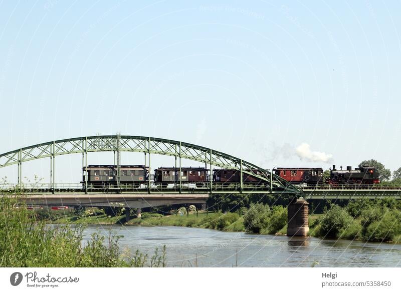 Historischer Zug fährt auf einer Eisenbahnbrücke über die Weser historisch alt Brücke Fluss Flussufer Überquerung Bahn Verkehr Architektur Transport Tourismus