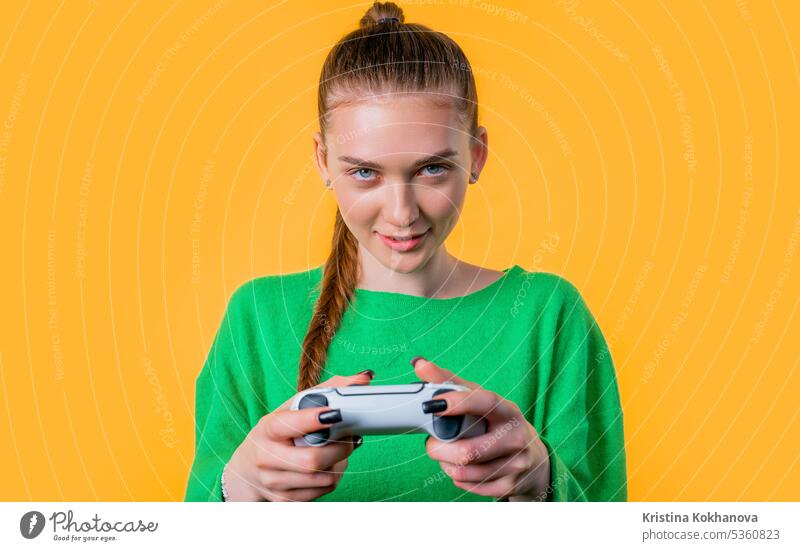 Junge Frau spielt Online-Videospiel, Konsole TV mit Joystick gelber Hintergrund Pfeil Schaltfläche Nahaufnahme Computer Kontrolle Regler elektronisch genießen