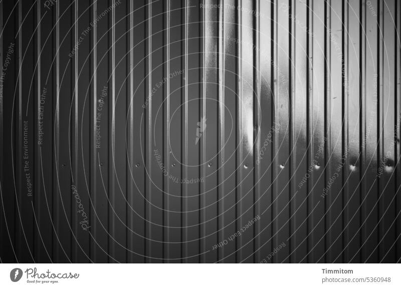 grau in grau | stählerner Zweckbau Metall Container Linien Nieten Delle Licht Schatten schwarz Menschenleer Schwarzweißfoto trashig Teilansicht