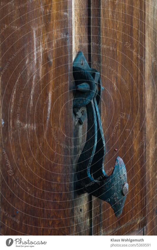 Türklopfer an einer alten Tür. Schmierfinken haben ihre Spuren hinterlassen. Alte Tür Metall Holz Eingang Nahaufnahme geschlossen Außenaufnahme Holztür