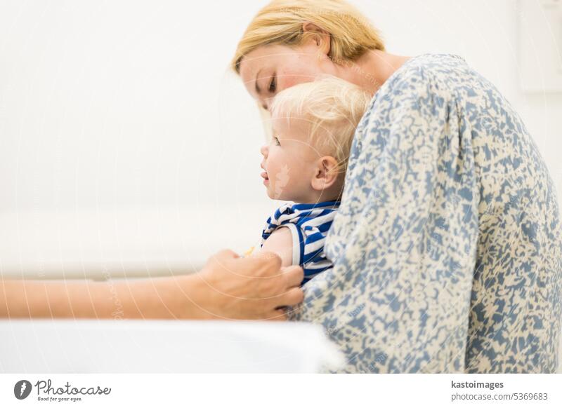 Das Kind wird vom Kinderarzt in Anwesenheit der Mutter geimpft. Vorbeugende Impfung gegen Diphtherie, Keuchhusten, Tetanus, Hepatitis, Hämophilus influenzae, Pneumokokken, Poliomyelitis