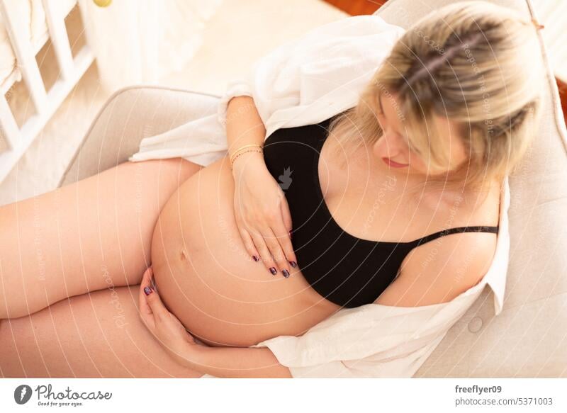 Junge schwangere Frau in Studiobeleuchtung Porträt jung blond Dreißigerjahre 30s Hemd Bauch Mutter Textfreiraum Schwangerschaft Eltern Elternschaft Mutterschaft
