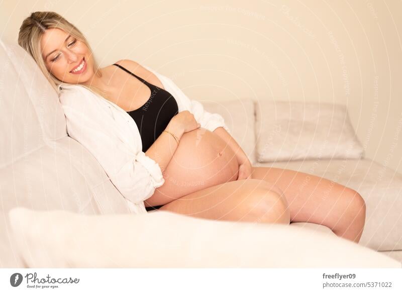 Junge schwangere Frau in Studiobeleuchtung Porträt jung blond Dreißigerjahre 30s Hemd Bauch Mutter Textfreiraum Schwangerschaft Eltern Elternschaft Mutterschaft