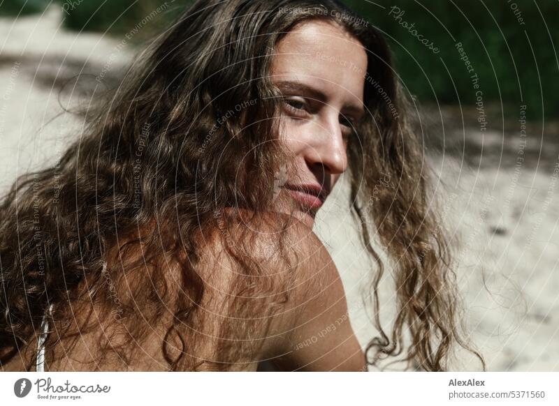 seitliches Portrait einer jungen, schönen, brünetten Frau mit Grübchen im Bikini am Strand warm sommerlich schönes wetter Sommer Nähe Tag Selbstbewußt