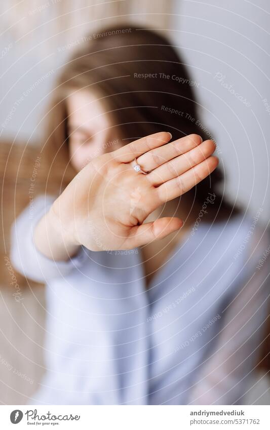 Junge Frau zeigt einen Ring mit Diamanten. Das Mädchen zeigt einen Verlobungsring an ihrem Finger. Sie hat Ja gesagt. selektiver Fokus auf die Hand. Engagement