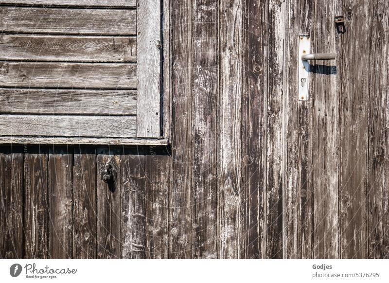 Hölzerne Fassade mit Tür und Fensterladen Holzfassade Haus Außenaufnahme Architektur Wand geschlossen Farbfoto Tag Gebäude Schuppen Türgriff grau trist