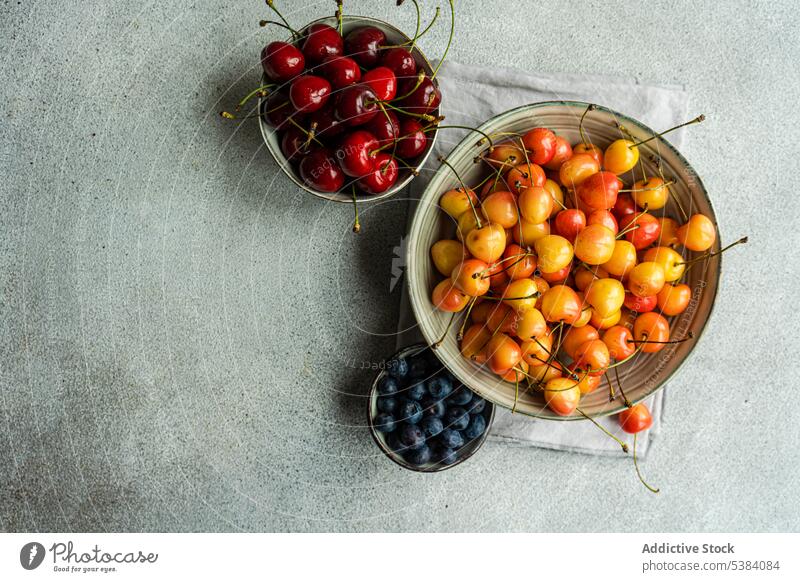 Süßkirschen in der Schale Sortiment Hintergrund Beeren blau Blaubeeren Schalen & Schüsseln Kirsche Beton Dessert essen Essen Lebensmittel frisch Frucht