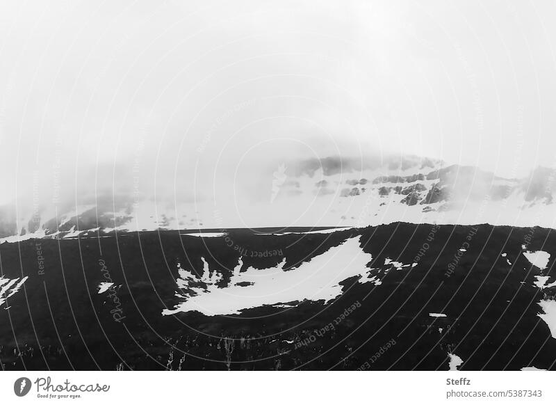 Bergseite mit bizarren Schneeformen auf Island Ostisland Islandstrolle unheimlich Naturformen Iceland Nebelschleier mysteriös geheimnisvoll dunkel mystisch